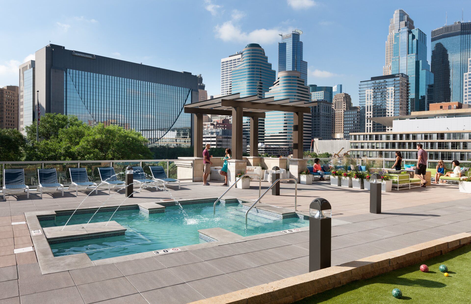A large swimming pool with a city skyline in the background at 222 Hennepin Apartments.