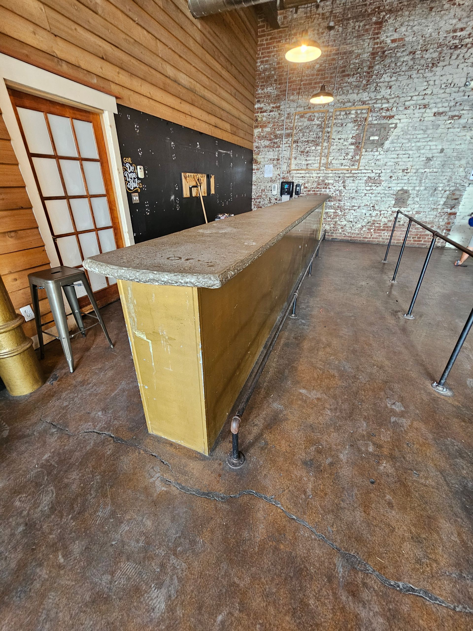 A blue trash can filled with old batteries on a table.