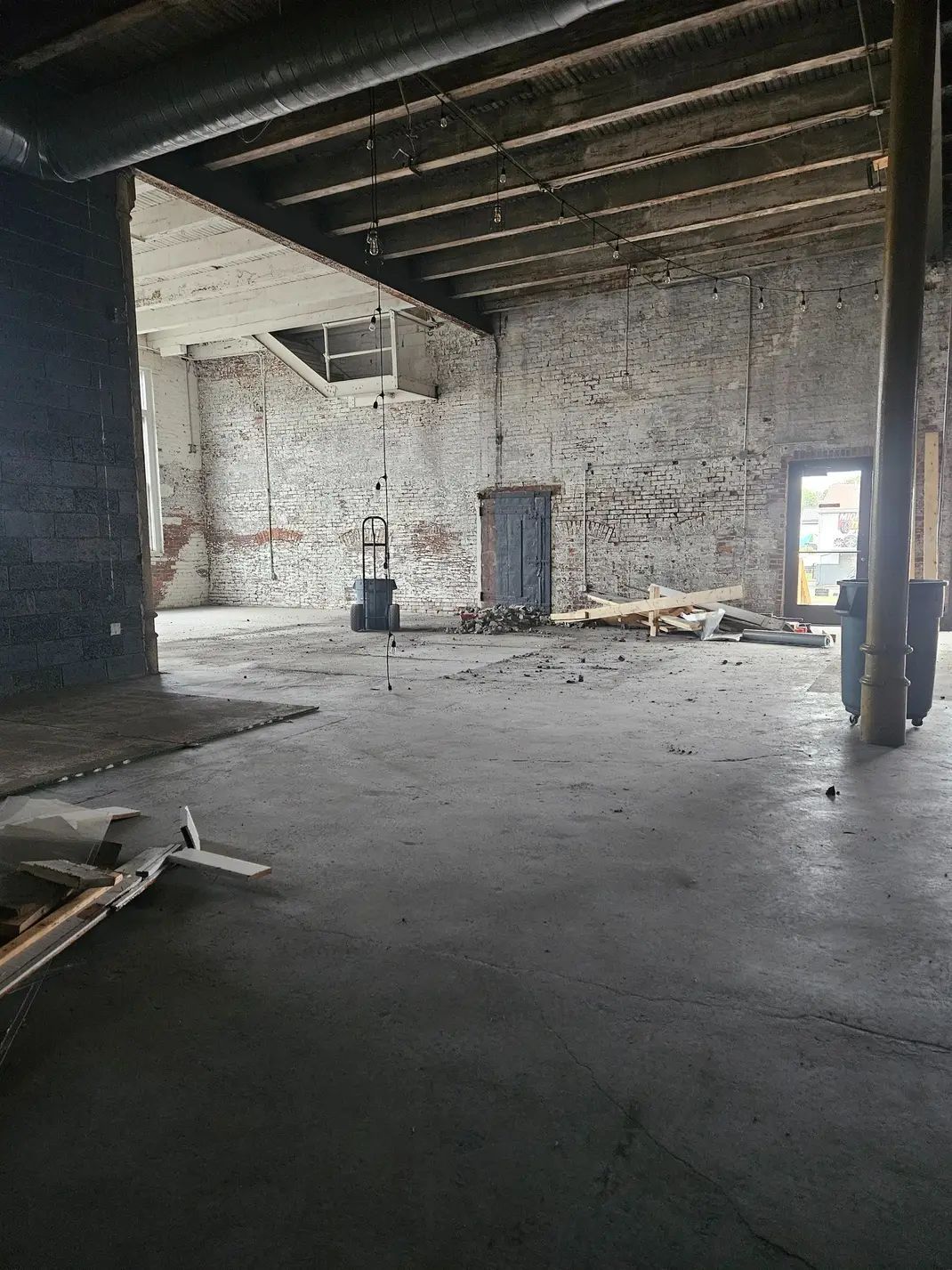 A blue trash can filled with old batteries on a table.