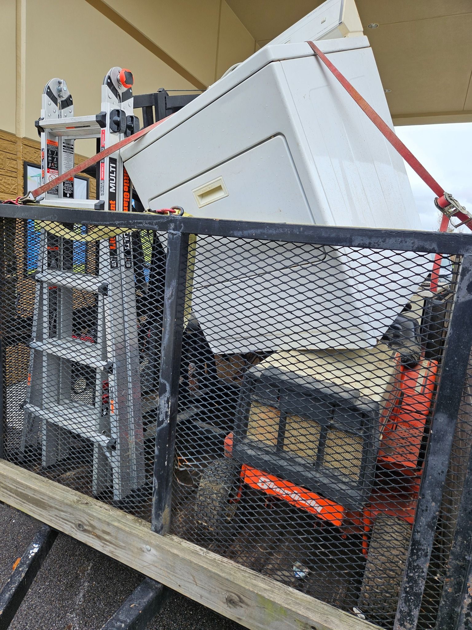 A pile of broken appliances against a blue sky