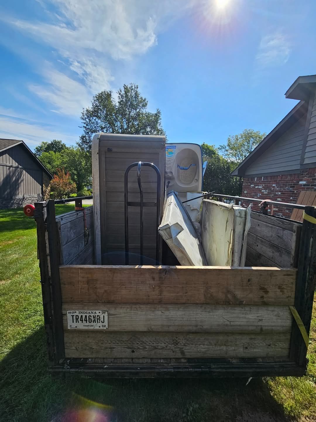 A blue trash can filled with old batteries on a table.