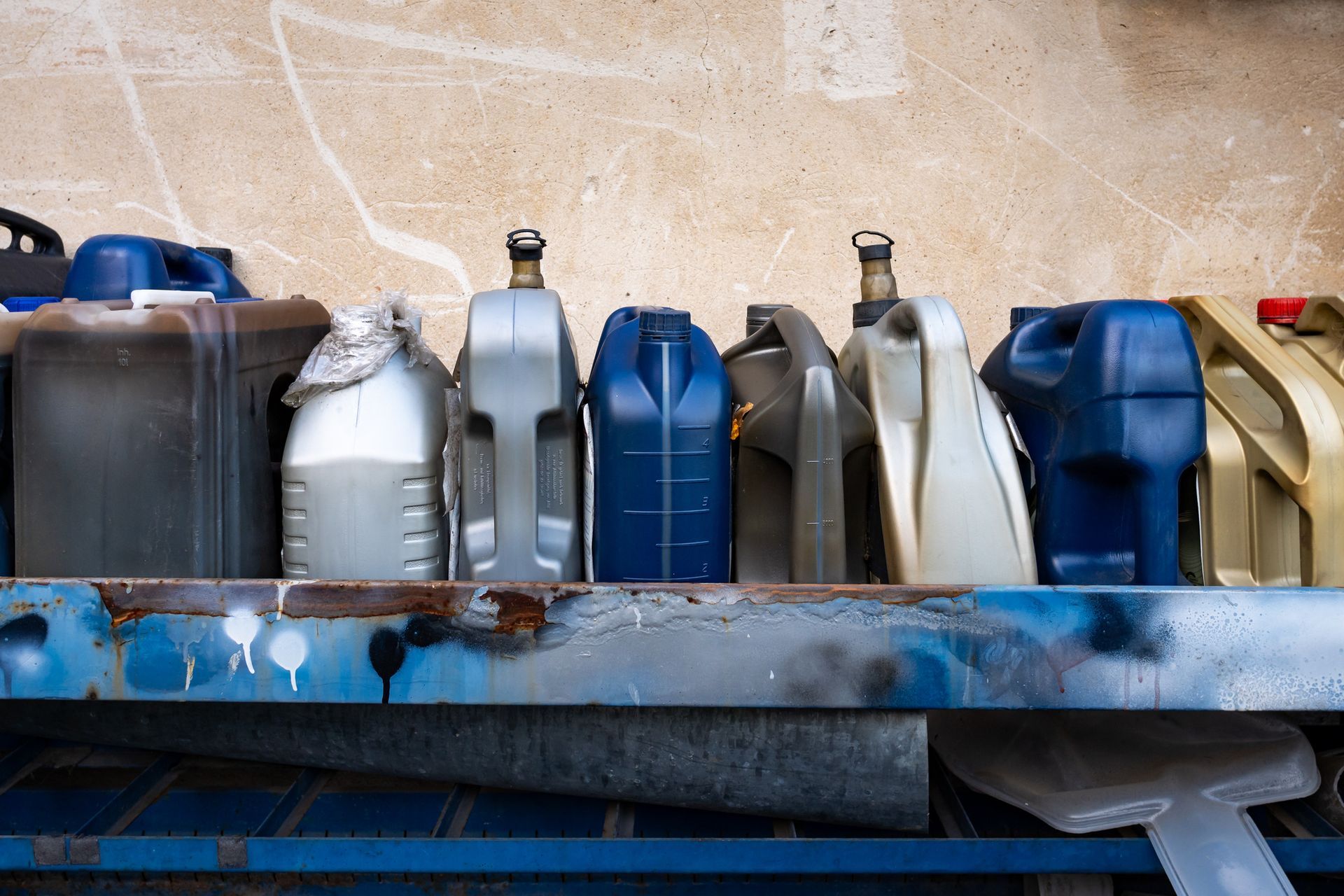 A row of plastic containers sitting on top of a metal shelf.
