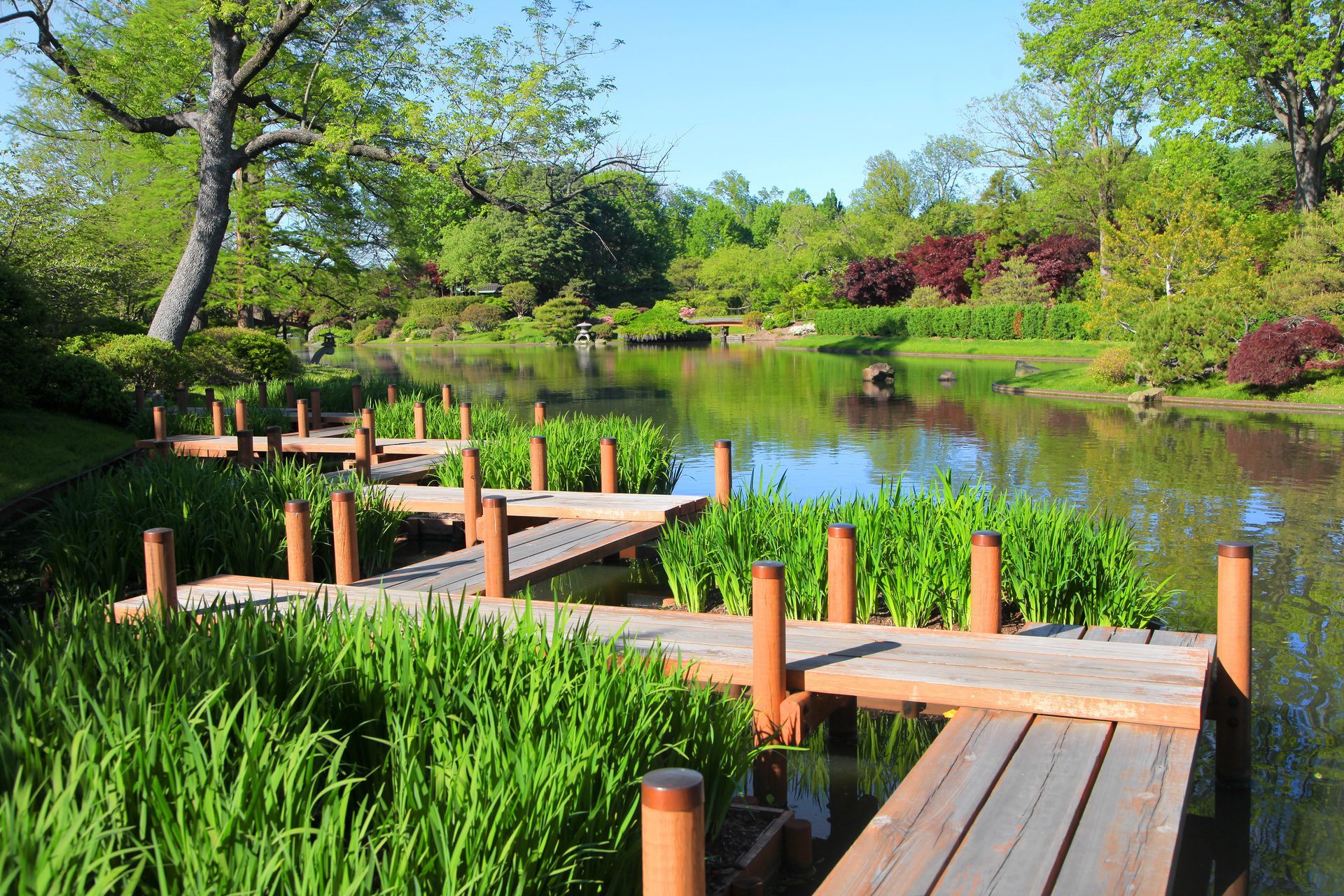 A wooden bridge over a body of water in a park