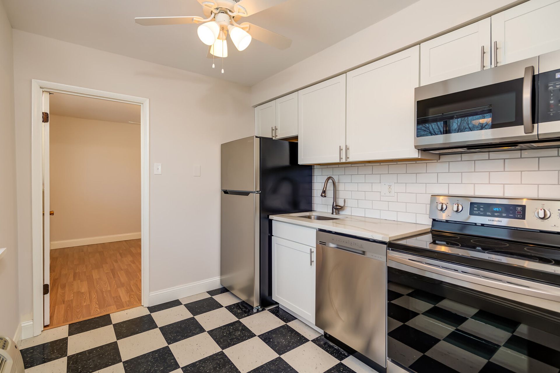 A kitchen with stainless steel appliances and white cabinets