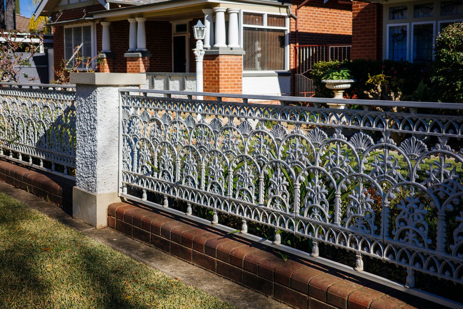 An iron fence in the front yard of a house.