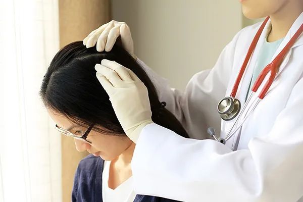 a doctor is examining a woman 's hair with a stethoscope .