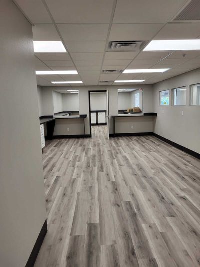 A large empty room with hardwood floors and white walls.