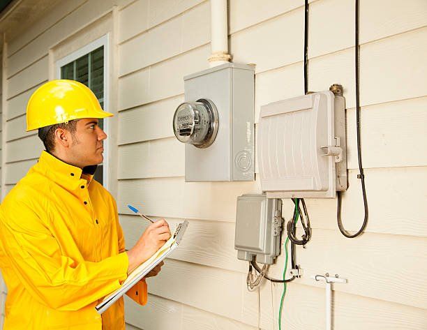 Electrician repairman at outside electric meter on home