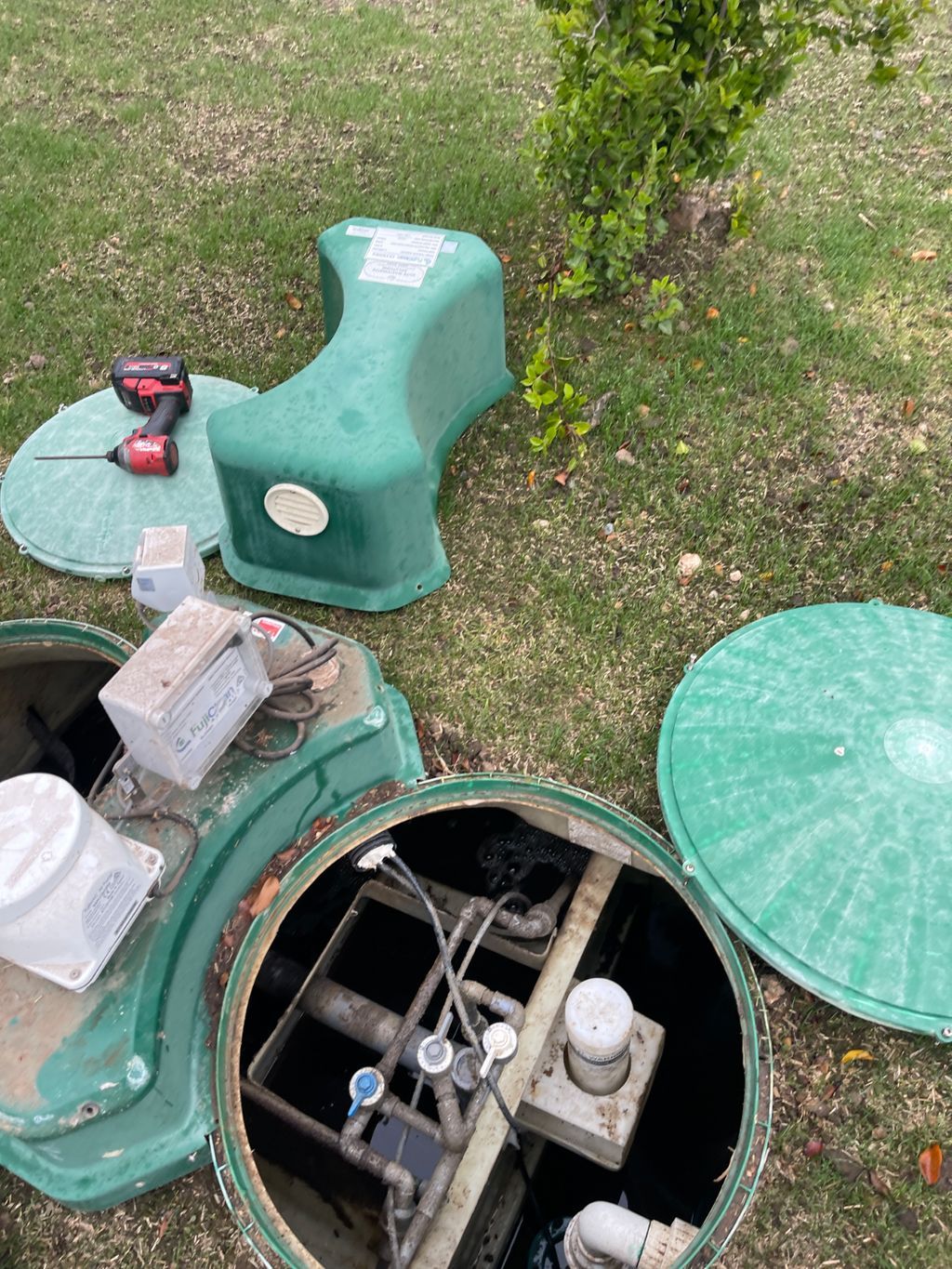 A Man is Installing a Pipe in a Hole in the Ground — Elite Wastewater Solutions in Fitzroy Falls, NSW
