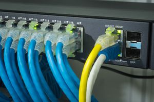 Network gigabit switch and UTP port cat 6 ethernet cables close-up in data server room