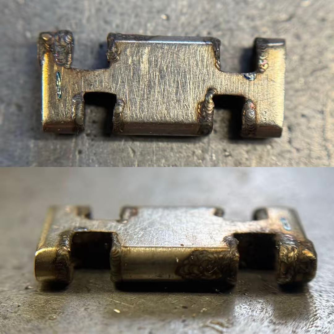 Vista da due angolazioni di una piccola maglia metallica rettangolare con tacche su entrambi i lati, che mostra segni di usura e tracce di saldatura.