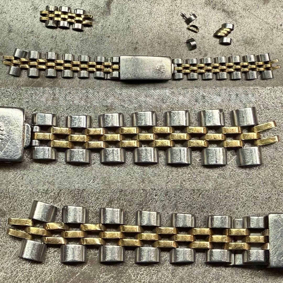 Un bracciale per orologio bicolore smontato, con maglie e perni extra disposti su una superficie grigia.