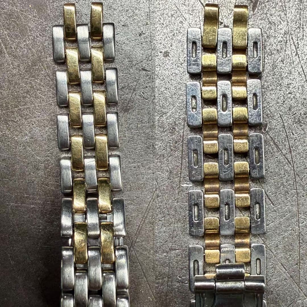 Due cinturini per orologi con maglie in oro e argento, posizionati uno accanto all'altro su una superficie metallica texturizzata.