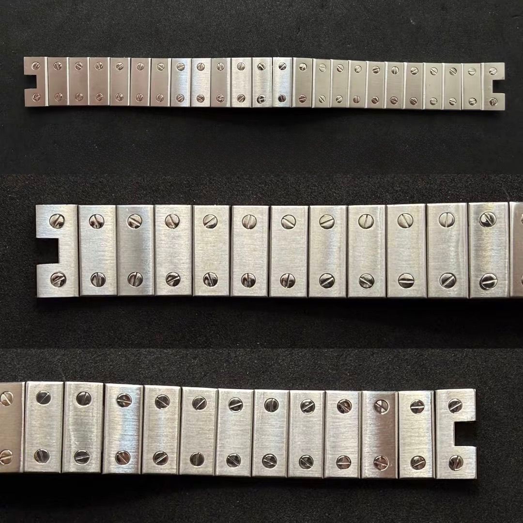 Tre segmenti di bracciale per orologio in acciaio inossidabile con regolazioni a vite, esposti orizzontalmente su una superficie scura.