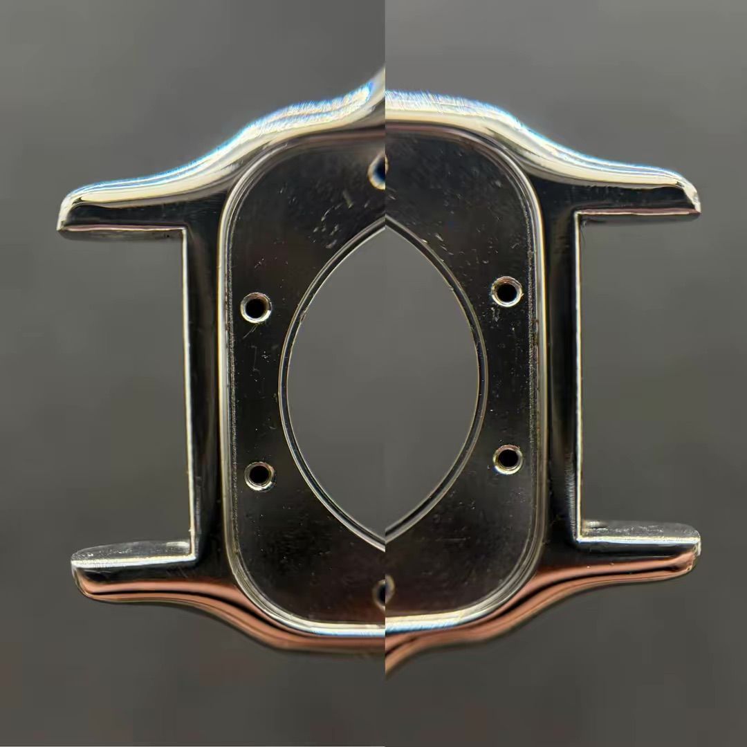 Un primo piano simmetrico e speculare di una cassa di orologio metallica argentata con due coppie di fori per le anse su uno sfondo scuro.