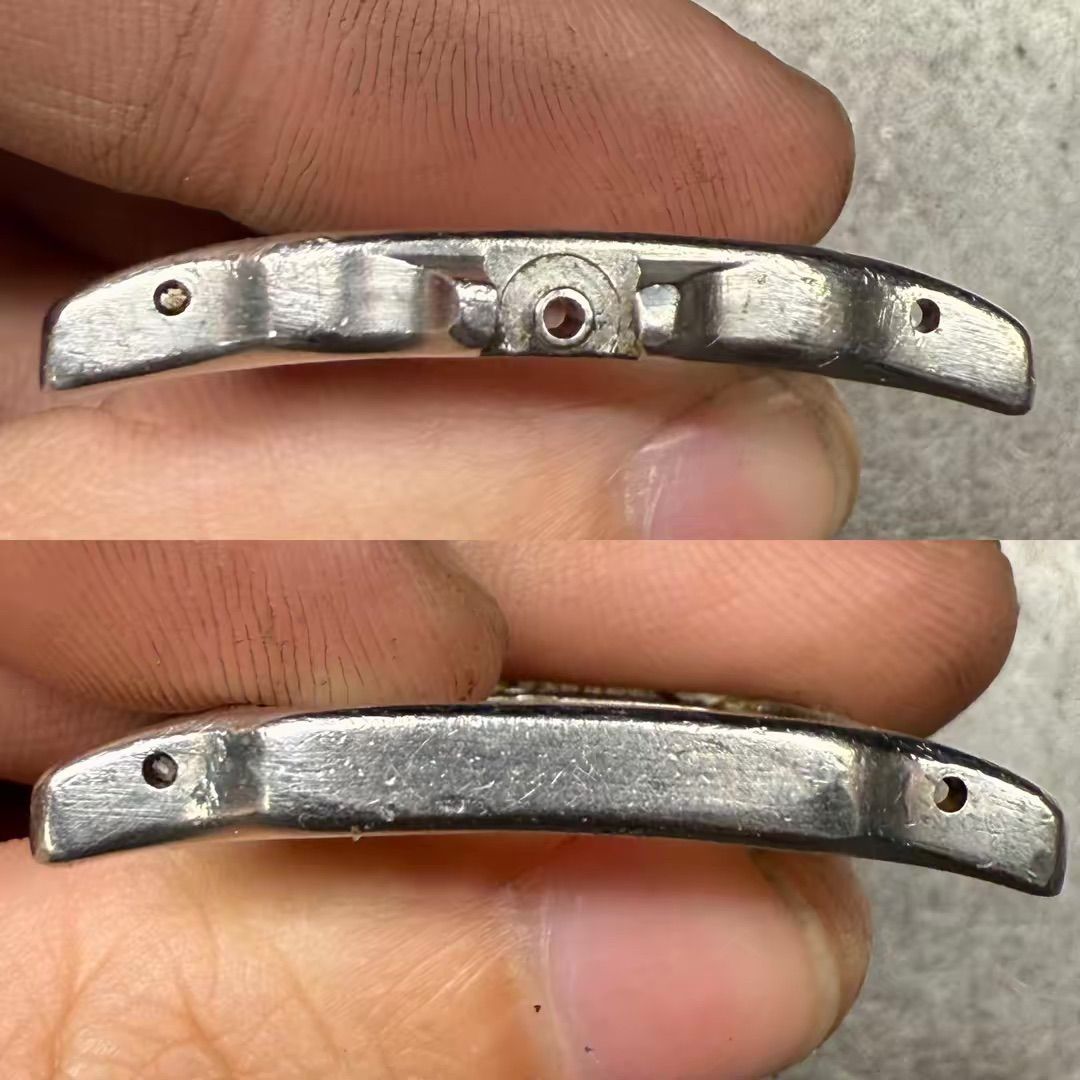 Un primo piano in due parti che mostra la vista dall'alto e dal basso di una maglia terminale curva in metallo di un orologio, dotata di tre piccoli fori.