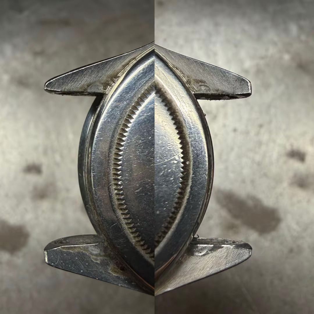 Una foto ravvicinata, con vista divisa, di una cassa di orologio metallica con anse, che mostra l'usura superficiale e un bordo circolare dalla texture particolare.