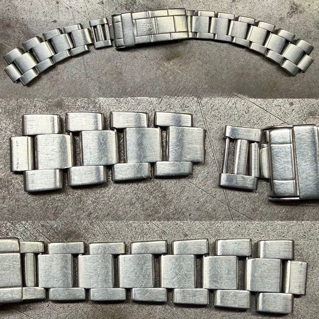 Tre segmenti di un bracciale per orologio in metallo color argento, mostrati separatamente su una superficie grigia ruvida.