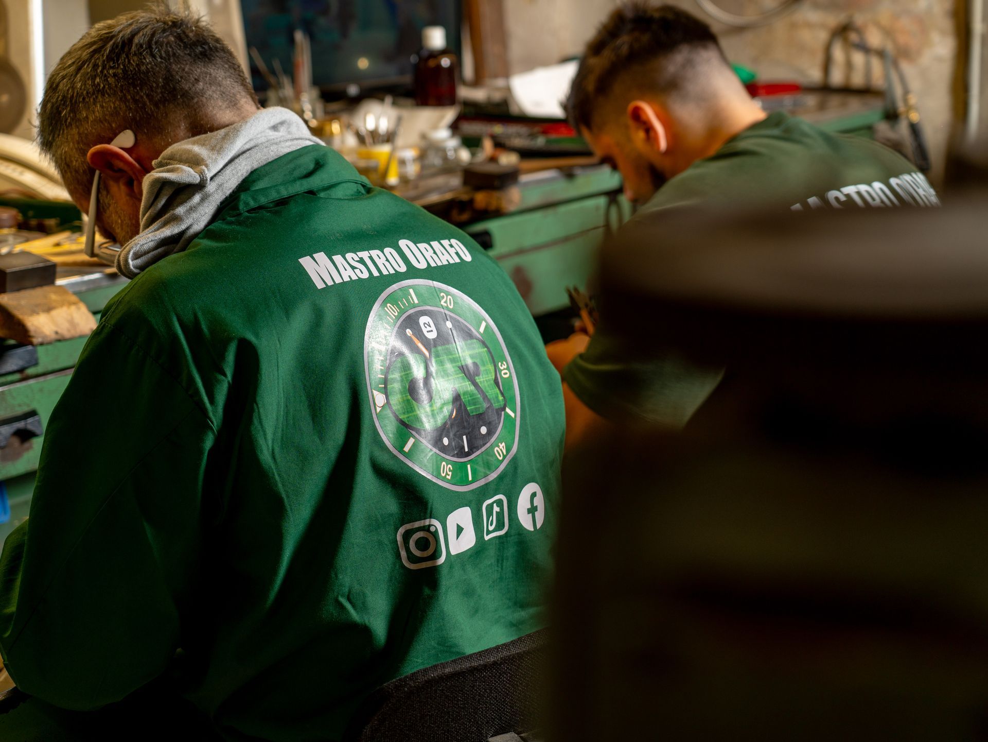 Due persone in uniforme verde con la scritta 