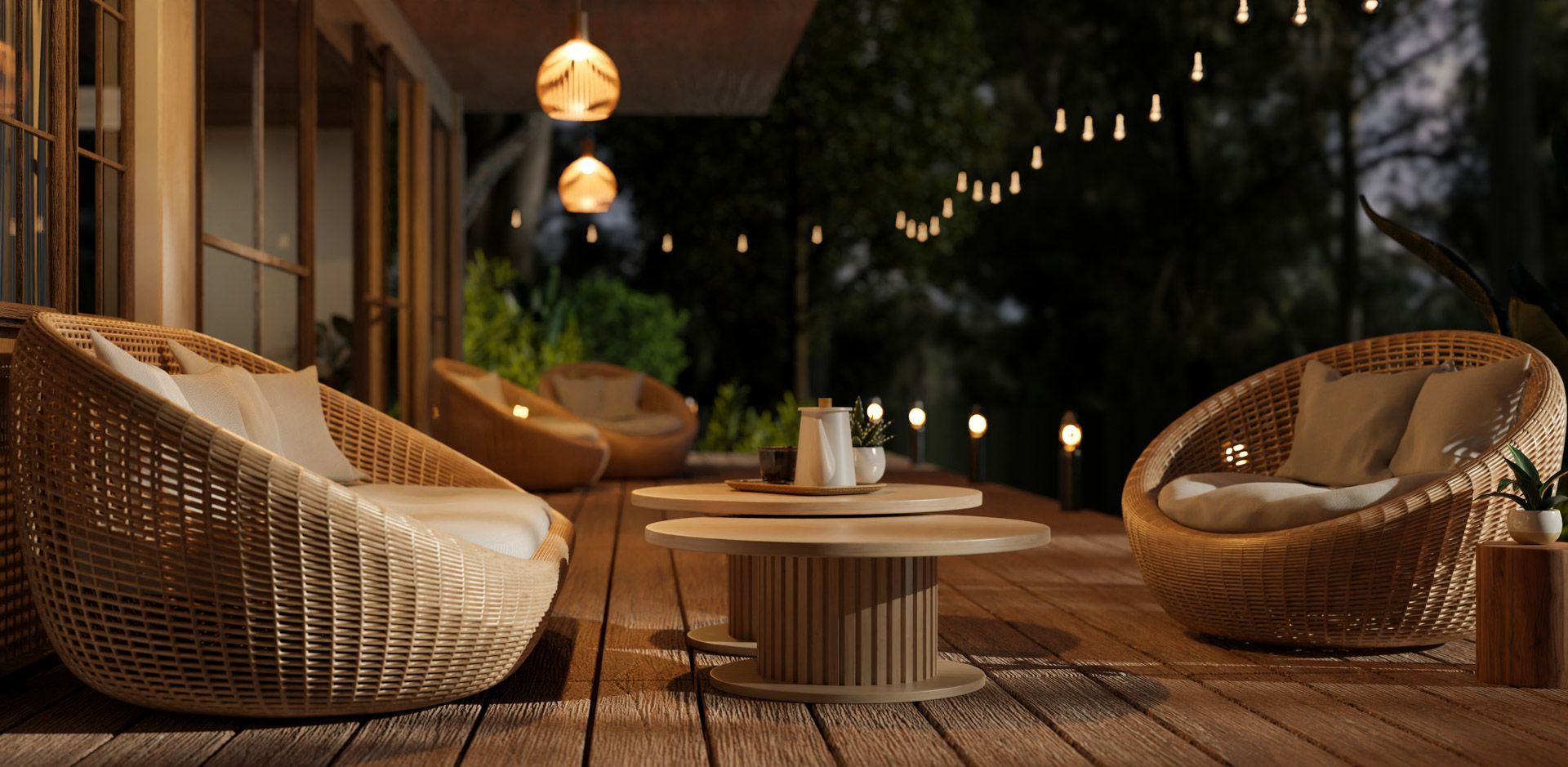 A wooden deck with wicker furniture and a table at night.