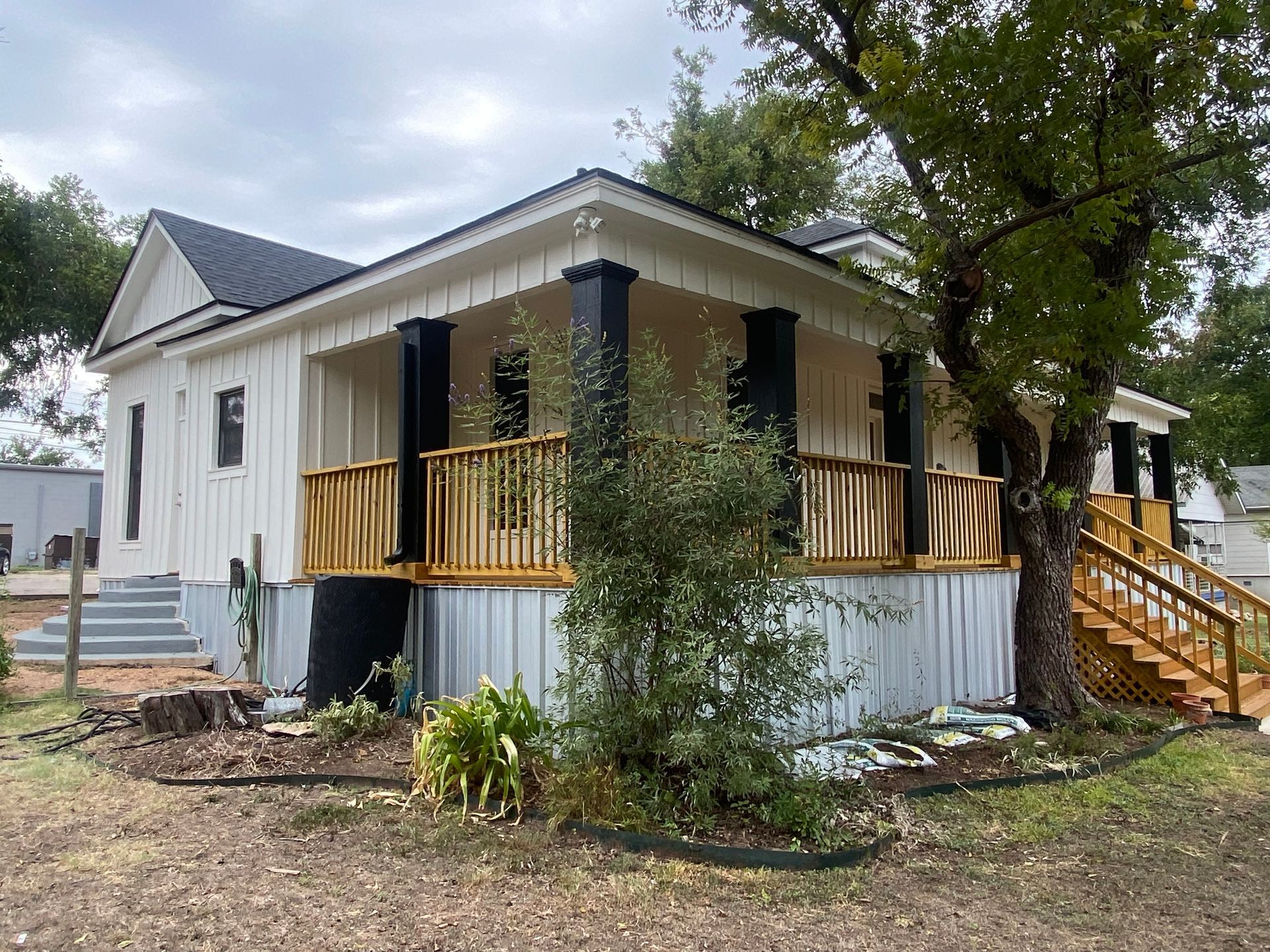 A white house with a large porch and stairs.