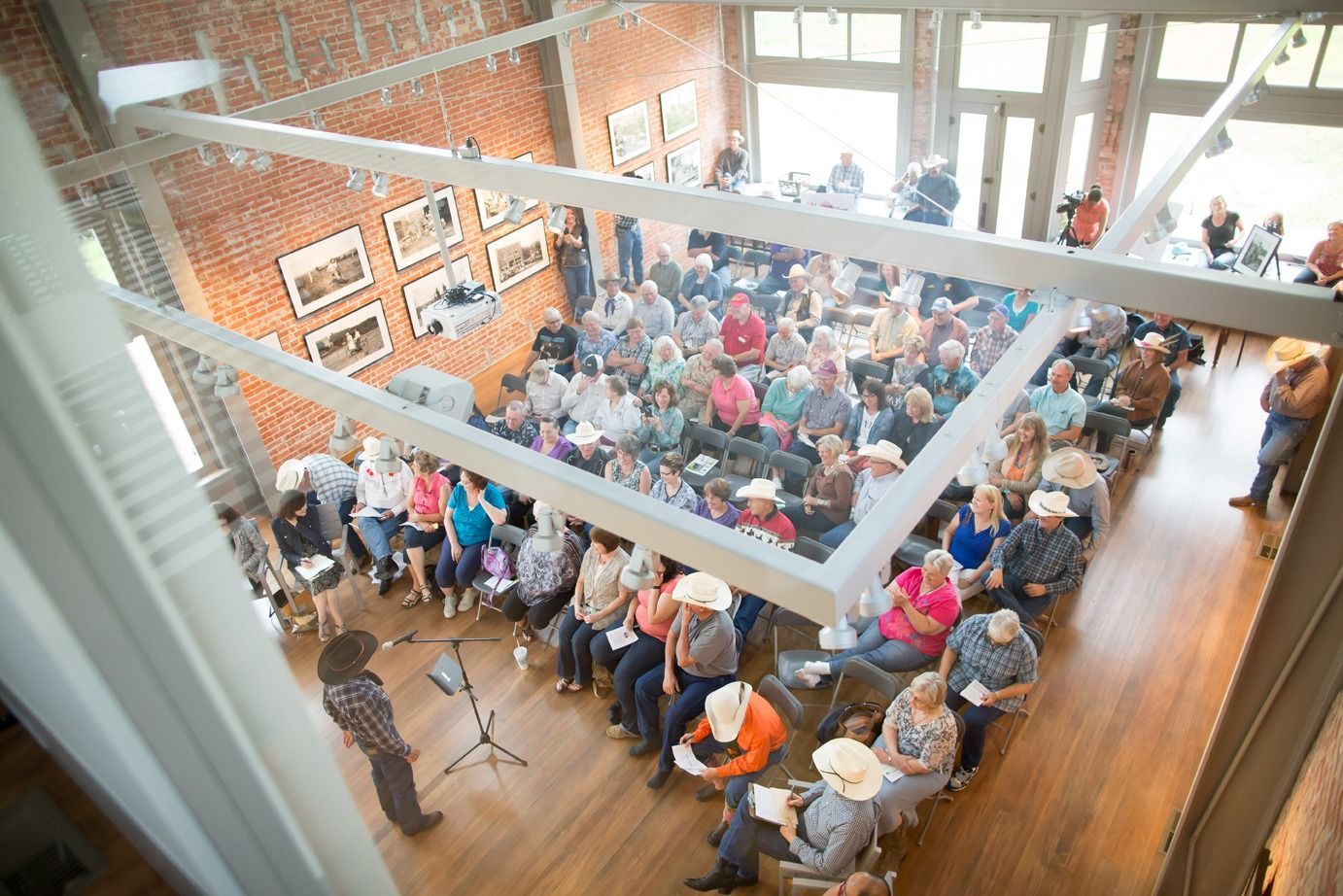 An aerial view of a large group of people sitting in a room.