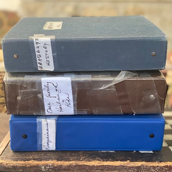 Three binders are stacked on top of each other with one labeled one friday