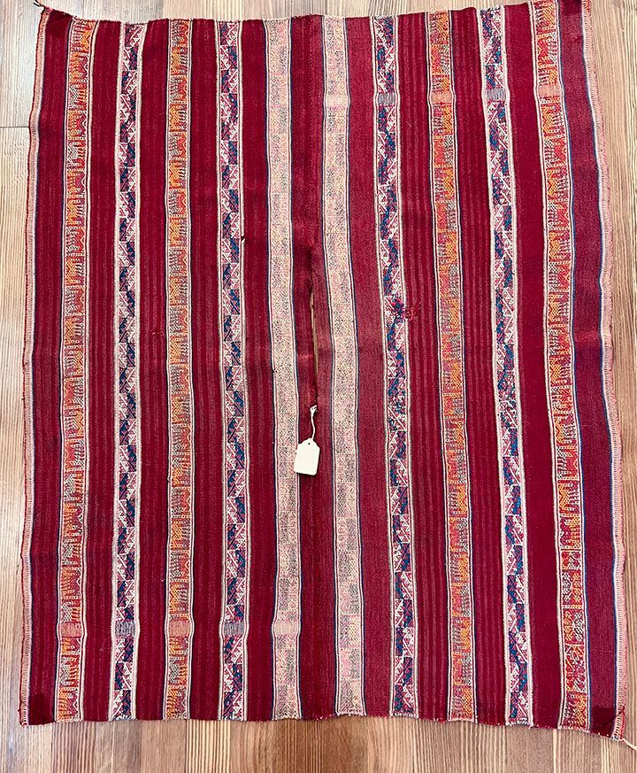 A red and white striped rug is sitting on a wooden floor.