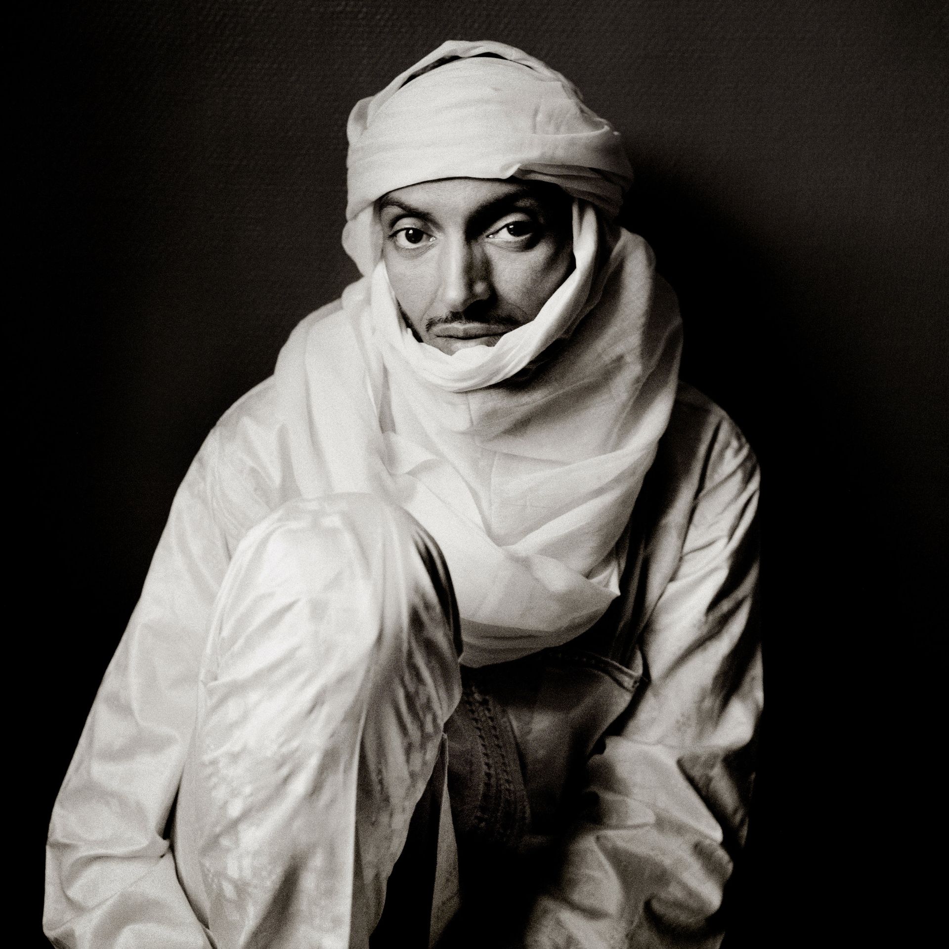A black and white photo of a man wearing a turban