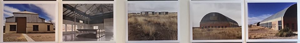 A row of pictures of buildings and landscapes are hanging on a wall.