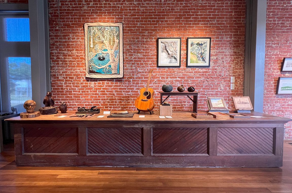 A long wooden counter in front of a brick wall.