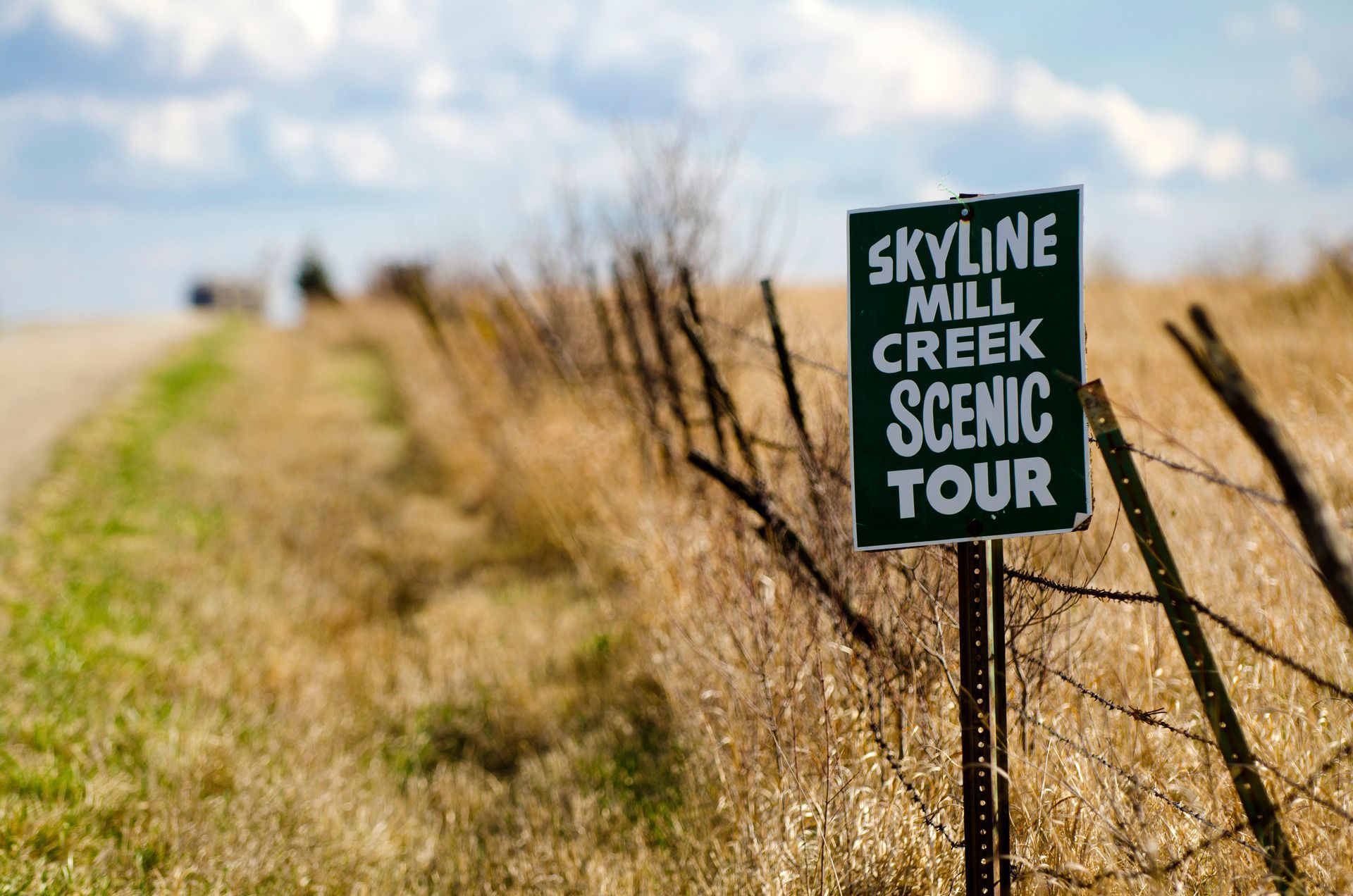 A sign in a field says skyline mill creek scenic tour.