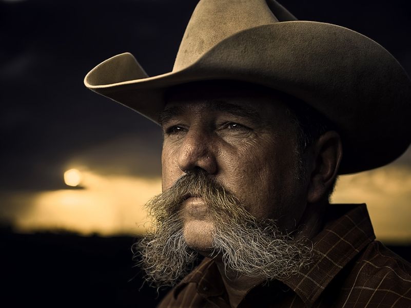 A man with a beard wearing a cowboy hat