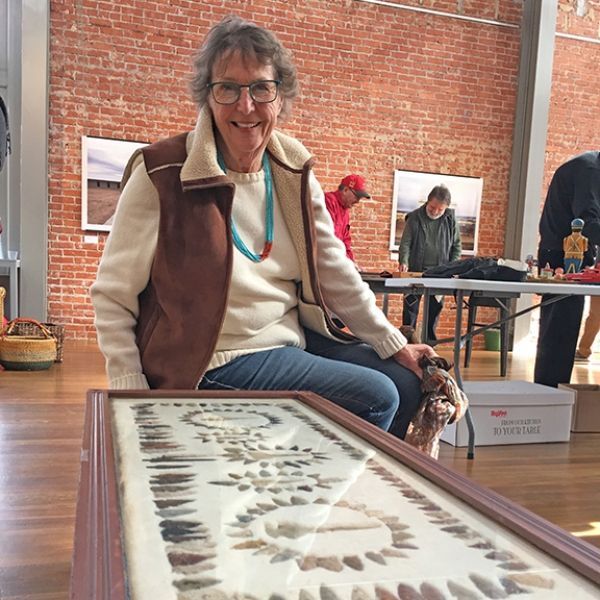 A woman sits on a table with a picture of a tree on it