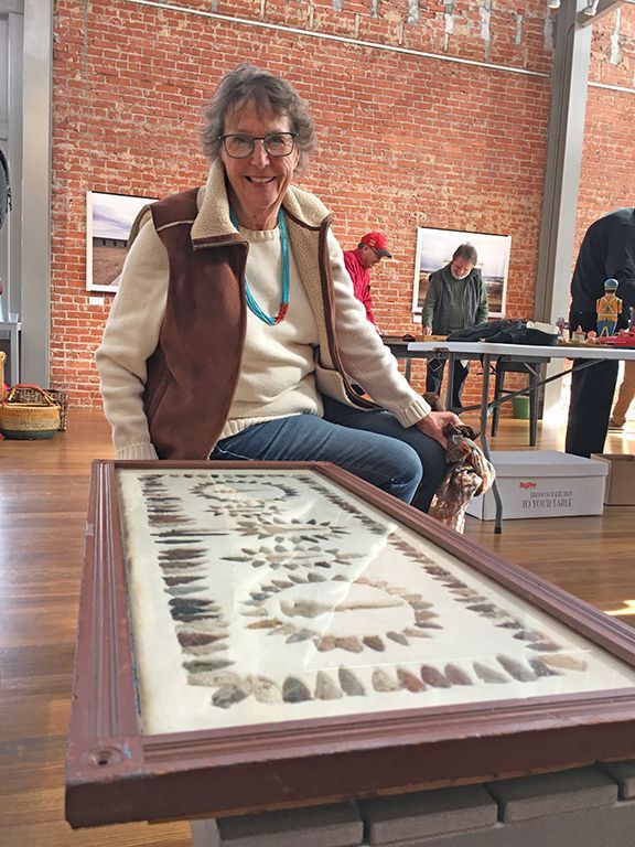 A woman is sitting on a table with a picture on it.