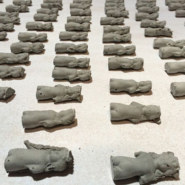 A row of clay figurines are lined up on a table