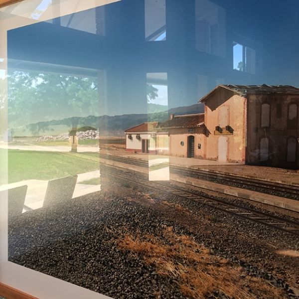 A picture of a train station with a building in the background