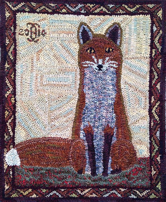 A fox is sitting in the grass on a rug.