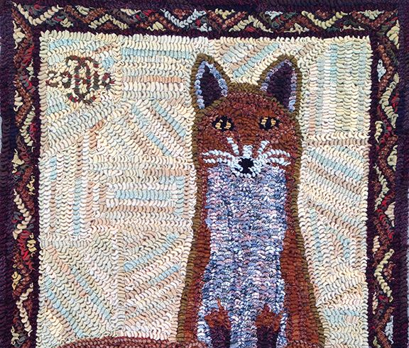 A fox is sitting in the grass on a rug.