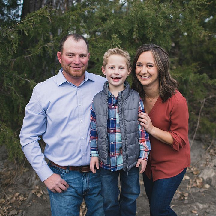 A man , woman and child are posing for a picture.
