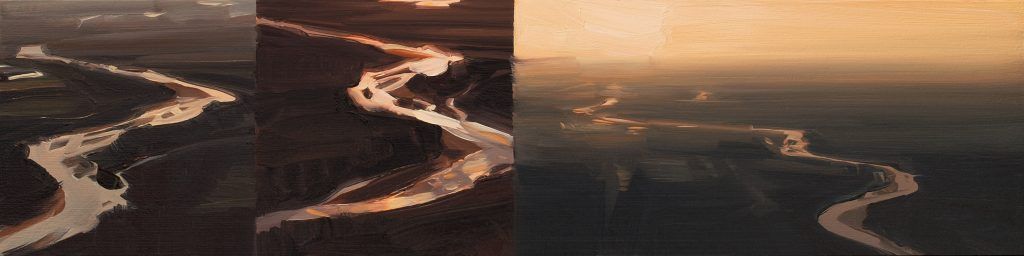 An aerial view of a river flowing through a valley at sunset.
