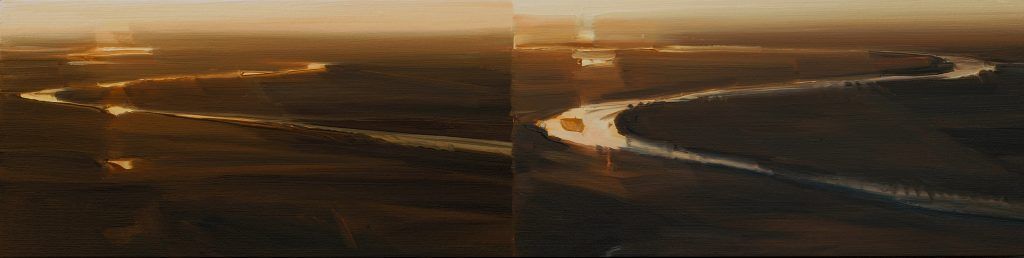 An aerial view of a bridge over a river at sunset.