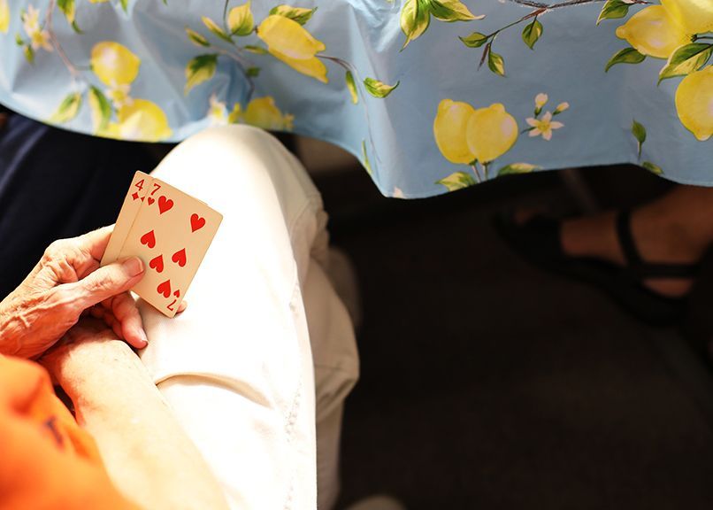 A person holding a playing card with hearts on it