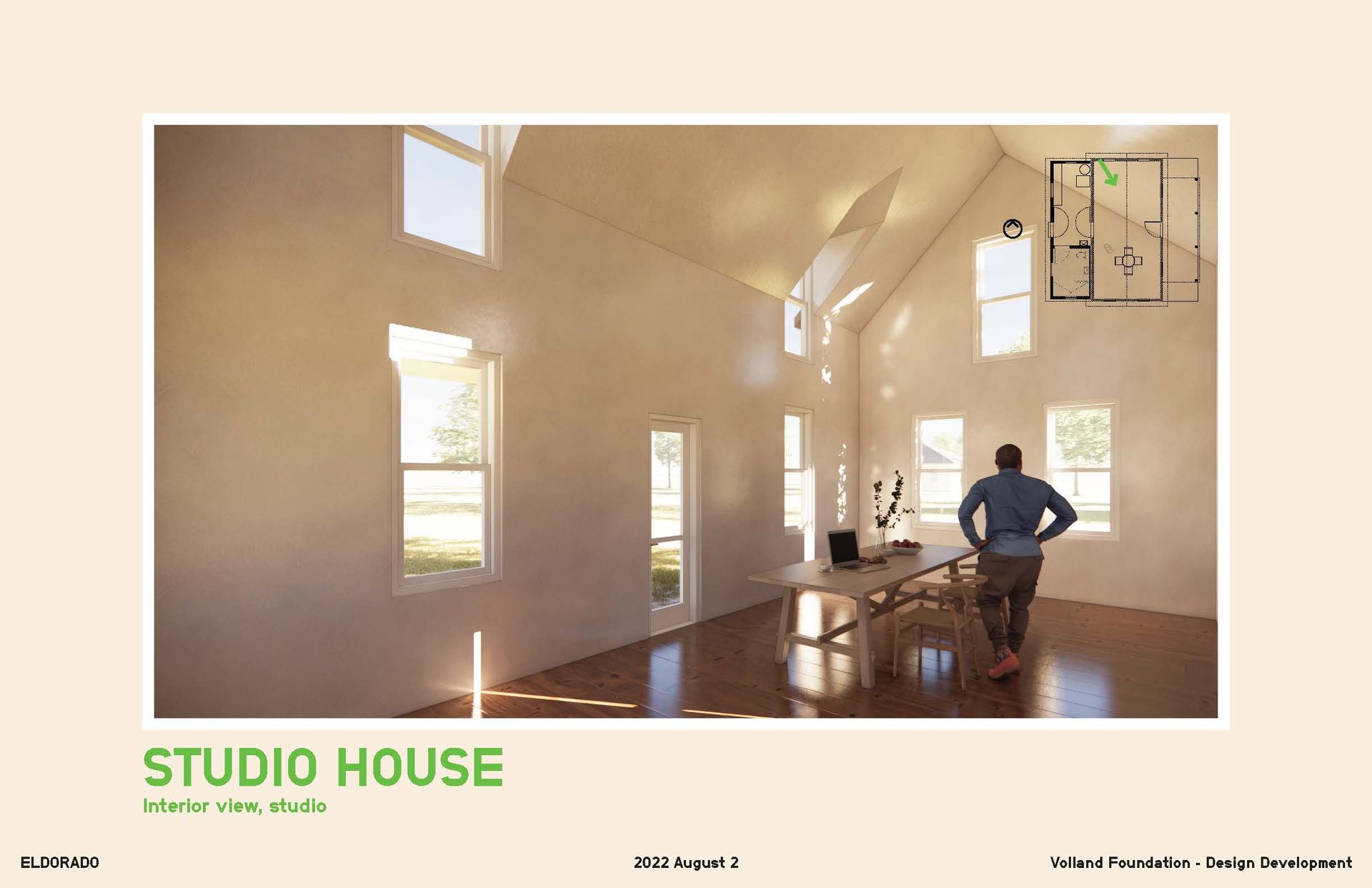 Interior of a studio house with natural light; a person stands near a table and windows.