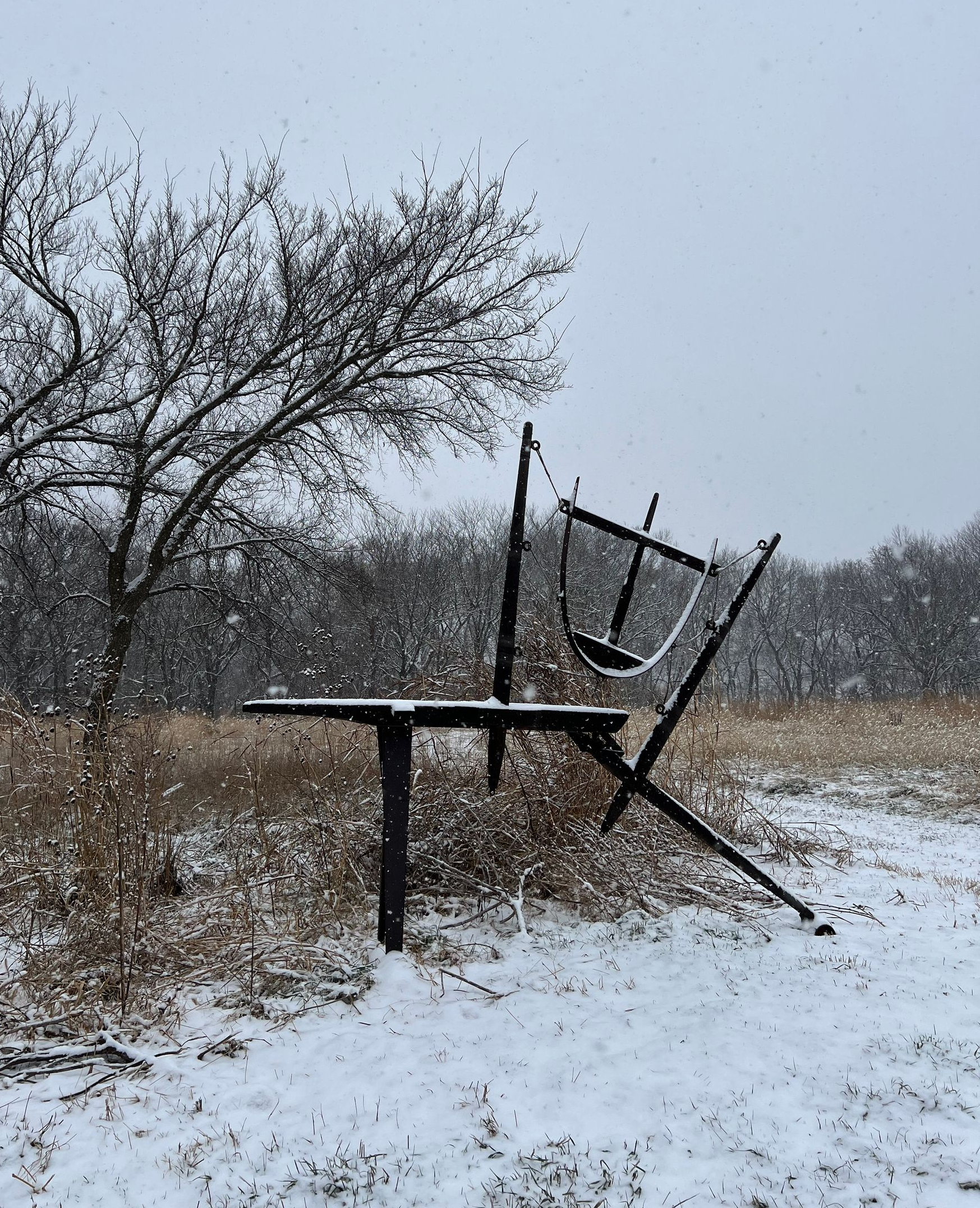 A man in a carhartt shirt is standing next to a wooden pole.