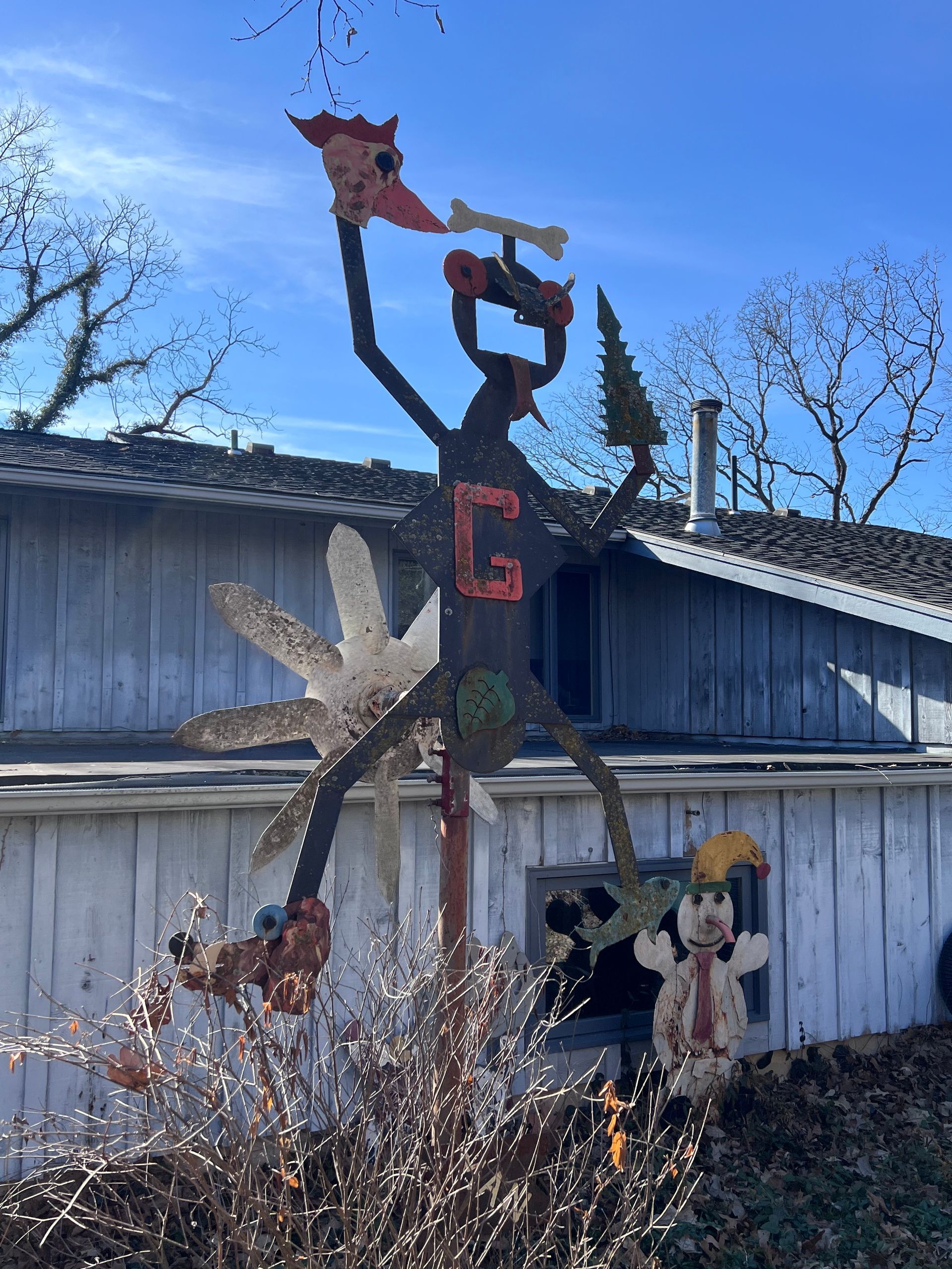 Whimsical folk art sculpture of a figure with red
