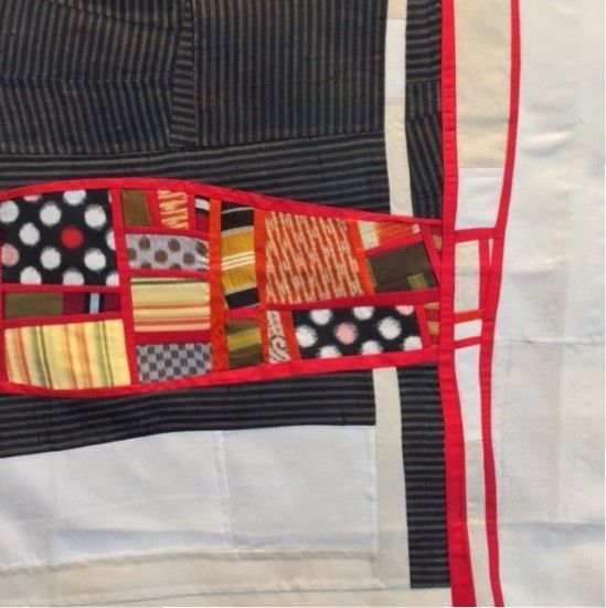 Quilt with black/white stripes, red outlines, and a patchwork of colorful fabric squares.