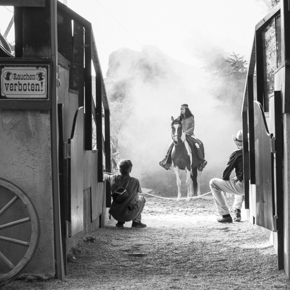 A black and white photo of a man riding a horse in front of a sign that says verboten