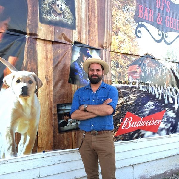 A man stands in front of a budweiser sign