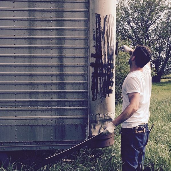 A man in a white shirt is painting a wall